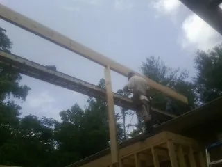 Carpenter setting a ridge beam over a new addition frame — Ice Dam Removal by Roofing Brothers in Mission Hills