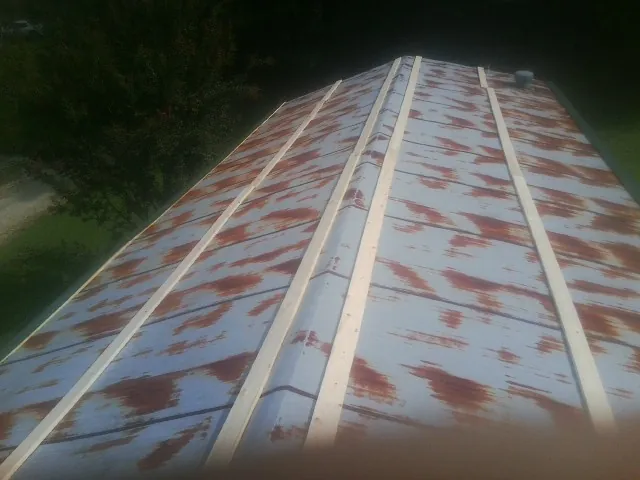 Rusted metal roof panels with new wood purlins before replacement — Storm Damage Roof Repair in Mission Hills by Roofing Brothers