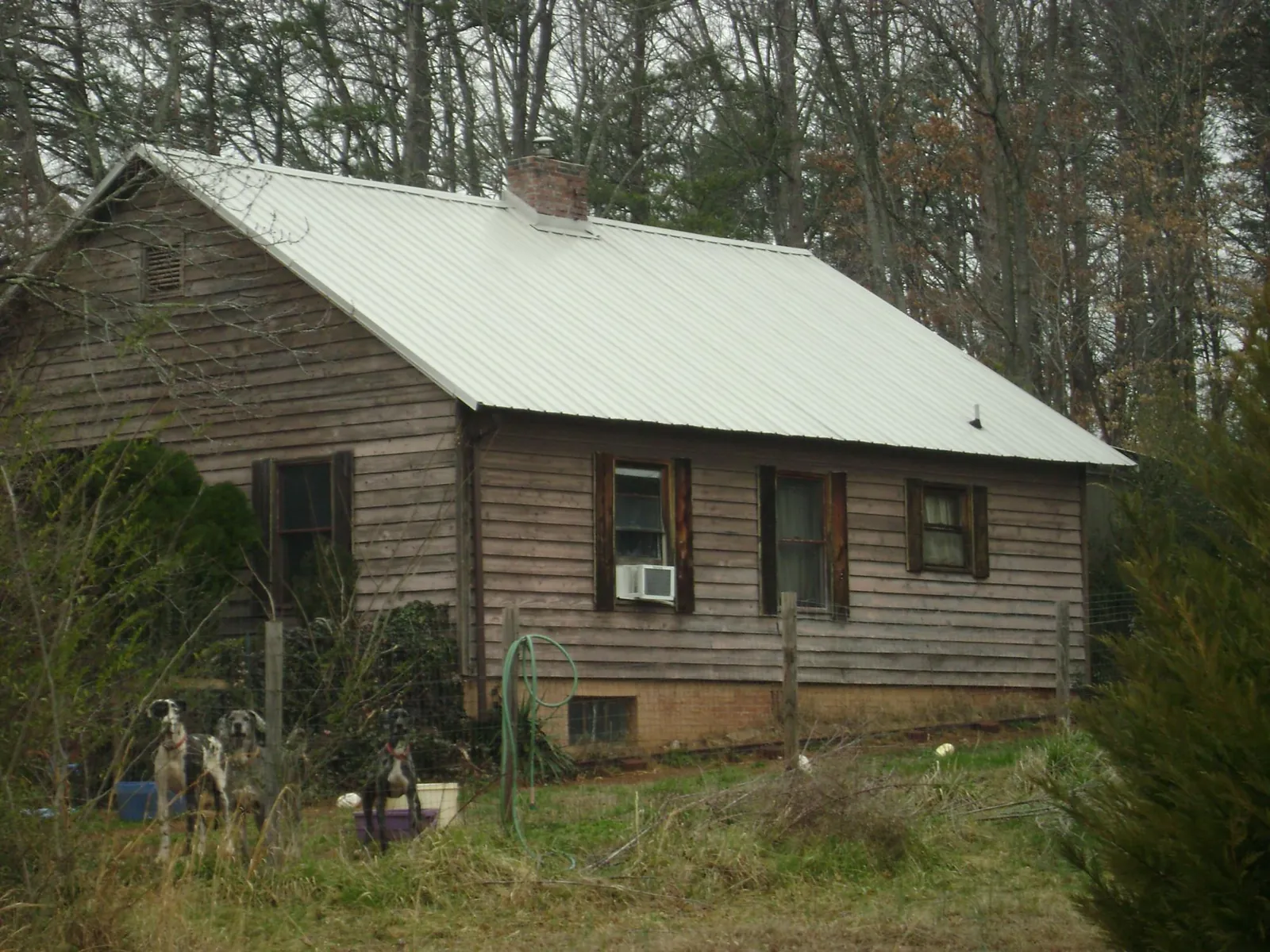 White metal roof on an old wood sided farmhouse, from a Metal Roof Installation job in Mission Hills